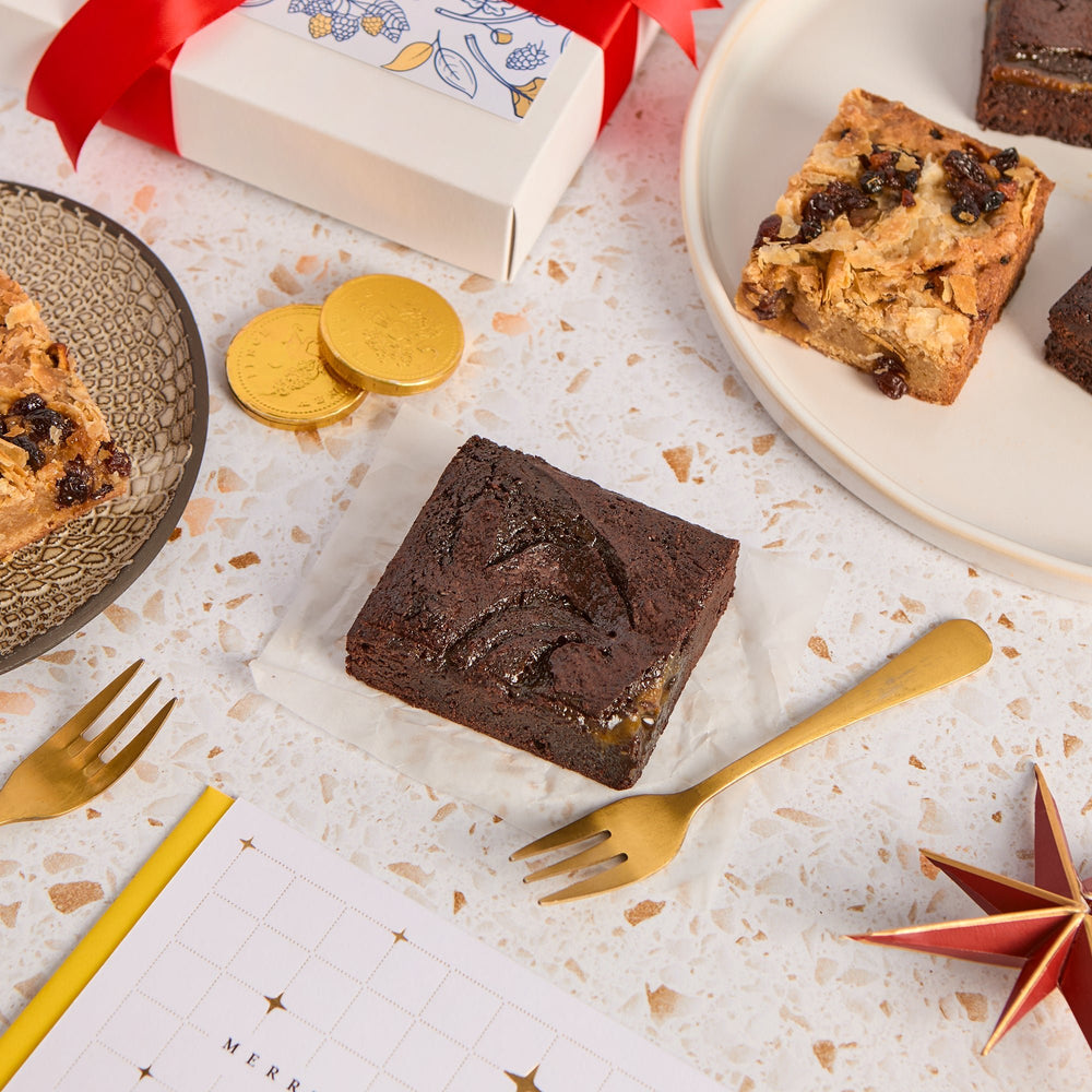 Baileys Caramel Brownie and mince pie blondie squares served with gold cutlery, Christmas gift box in background