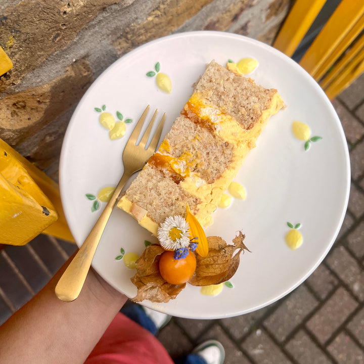 Slice of mango & coconut cake showing mango jam and buttercream layers