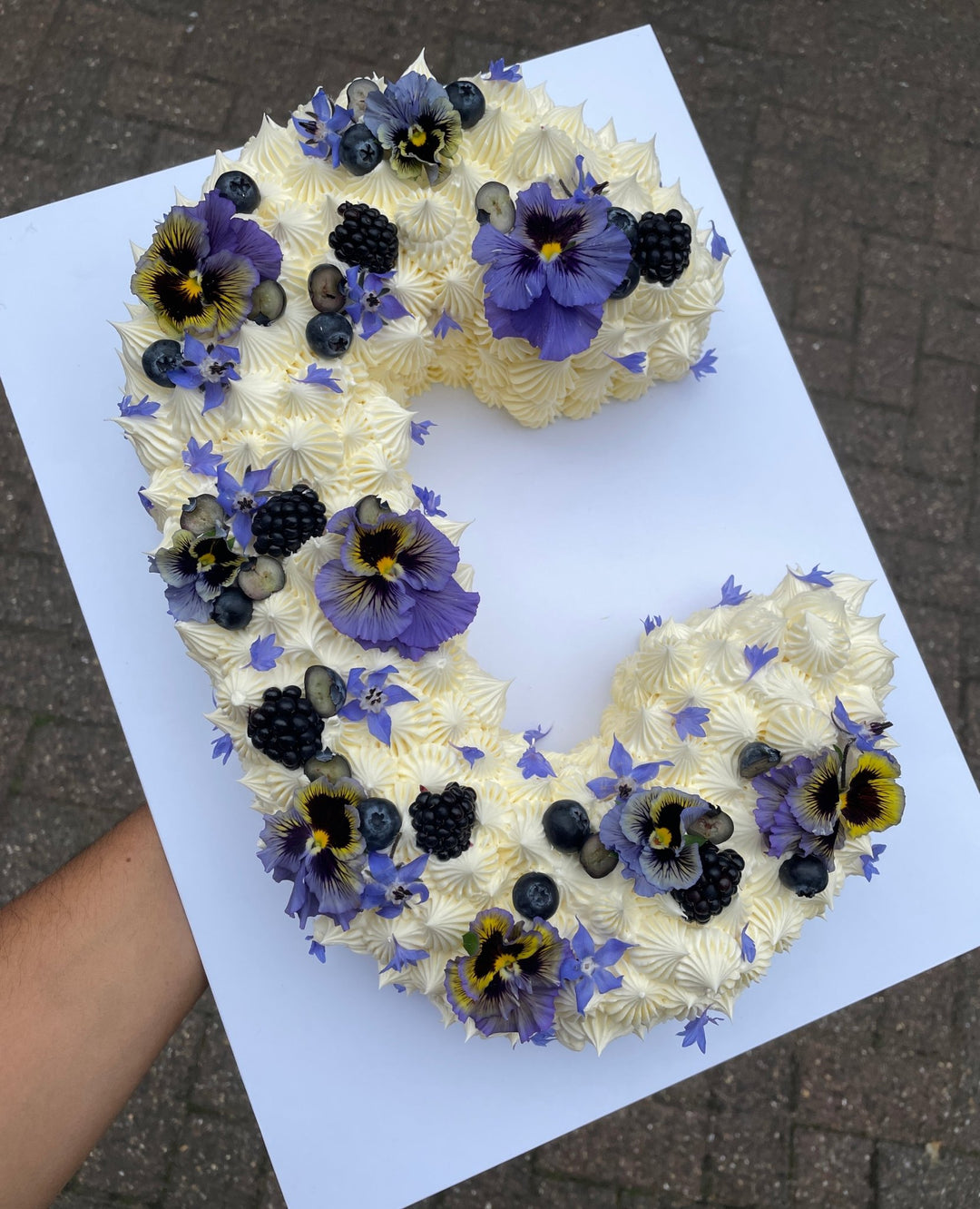 Letter C cake decorated with blackberries and blue flowers. London delivery