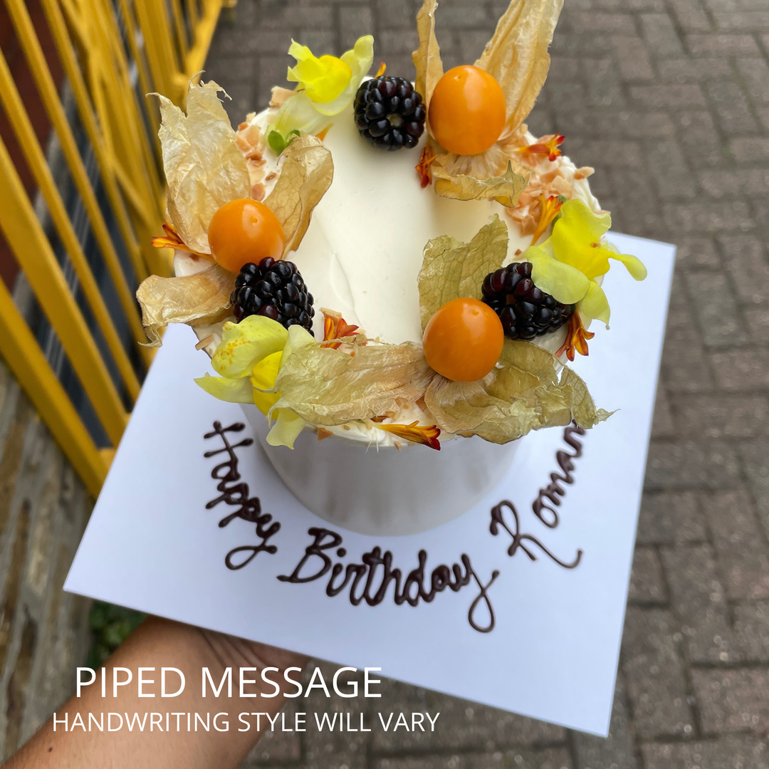 Birthday cake with piped 'Happy Birthday' message, physalis and blackberries
