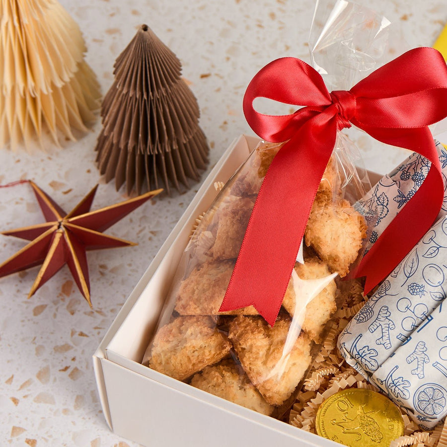 Coconut macaroon snowballs gift-wrapped with red ribbon in a Christmas gift box