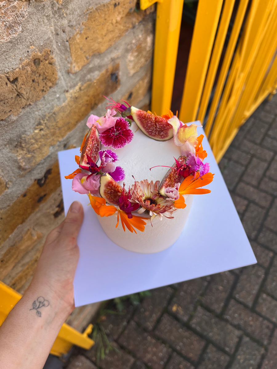 Vanilla & raspberry cake decorated with figs and fresh edible flowers, London