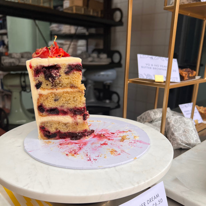 Slice of Summer Dream cake showing berry-filled sponge layers and lemon mascarpone filling