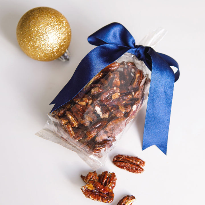 Bag of caramelised pecans tied with a blue satin ribbon, Christmas gift packaging